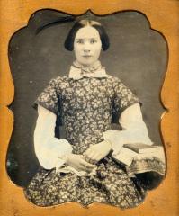 Woman seated with book, circa 1855